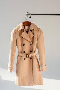 A trench coat is an essential piece in a wardrobe according to Indiana Wardrobe Stylist Beth Divine image shows coat on hook