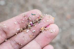 Personal Image Consultant Beth Divine encourages reducing microplastic pollution with clothing image shows fingers with microplastic materials