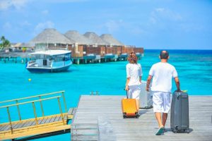 Learn some pointers for packing for a beach trip from Personal Image Consultant Beth Divine image shows couple arriving for a vacation