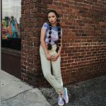 Indianapolis Women's Styling expert Beth Divine notes sneakers can provide fashion and function image shows woman wearing sneakers leaning against brick wall
