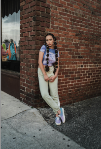 Indianapolis Women's Styling expert Beth Divine notes that sneakers can provide fashion and function image shows woman wearing sneakers leaning against brick wall