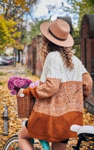 Boho cardigans are one of many upcoming Indianapolis Women's Styling trends image shows woman riding bike in fall weather