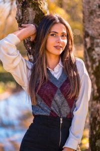 argyle cardigans work for those with the classic or elegant fashion style according to Indianapolis Women's Styling expert Beth Divine image shows woman in cardigan leaning against tree