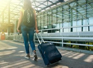 Indiana Women's Stylist expert Beth Divine recommends picking the right luggage when planning to travel image shows woman walking with suitcase