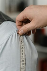 Work with Carmel Personal Stylist Beth Divine to maintain style during weight loss image shows hand measuring clothing
