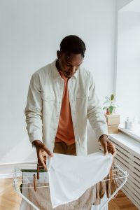 Work with Carmel Personal Stylist Beth Divine to identify clothes that don't irritate your skin image shows man placing laundry on dryer