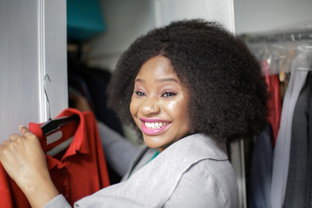 Make purchases you end up wearing with help from Carmel Wardrobe Stylist Beth Divine image shows smiling woman holding red shirt on hanger